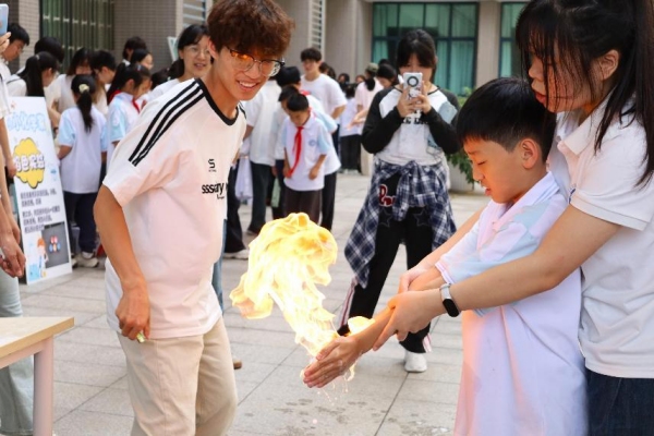 小朋友们在室外广场体验“火焰掌”实验。今年会jinnian官网供图 小朋友们在室外广场体验“火焰掌”实验。今年会jinnian官网供图